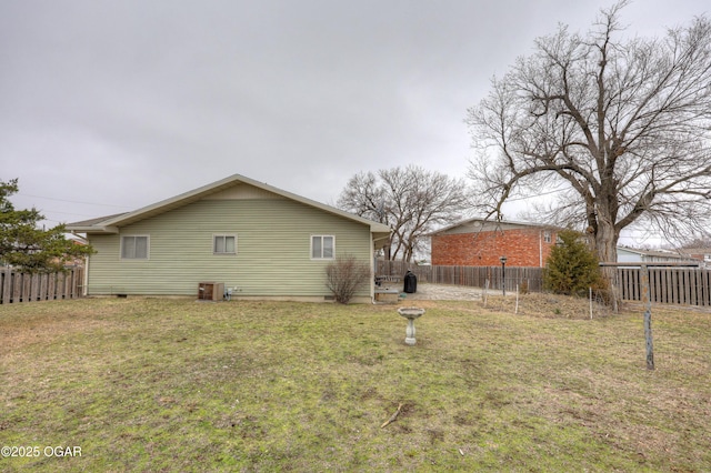 view of side of property with central AC and a lawn