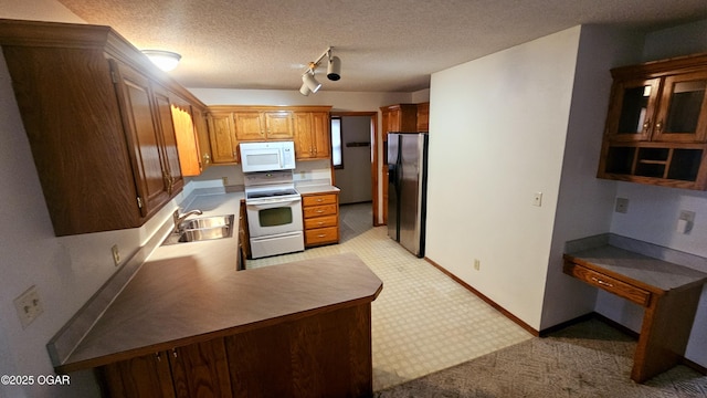 kitchen with sink, light carpet, a textured ceiling, kitchen peninsula, and white appliances