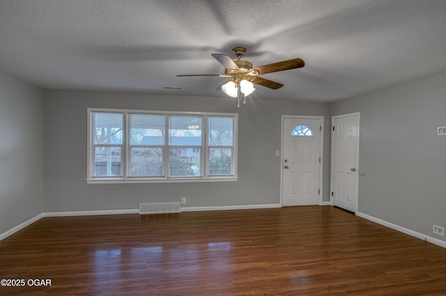 entryway with dark hardwood / wood-style flooring, a textured ceiling, and a healthy amount of sunlight