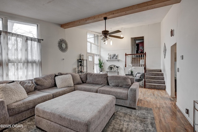 living room with ceiling fan, hardwood / wood-style flooring, and beamed ceiling