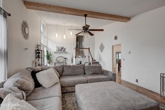 living room featuring ceiling fan, plenty of natural light, dark hardwood / wood-style floors, and beam ceiling