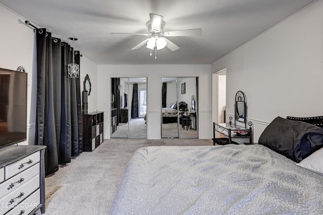 carpeted bedroom with two closets and ceiling fan