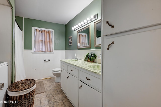 bathroom featuring washer / clothes dryer, vanity, and toilet