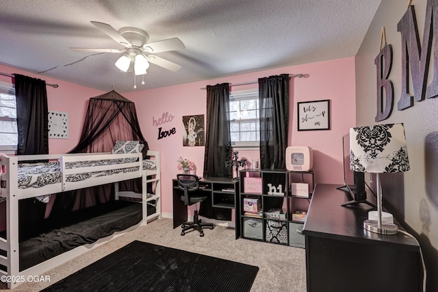 carpeted bedroom with ceiling fan and a textured ceiling