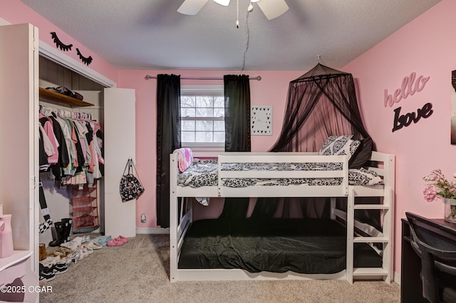 carpeted bedroom featuring ceiling fan, a closet, and a textured ceiling