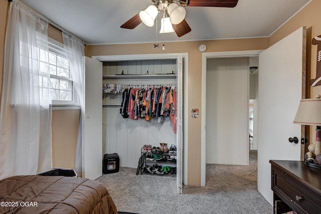 bedroom featuring ceiling fan, light carpet, and a closet