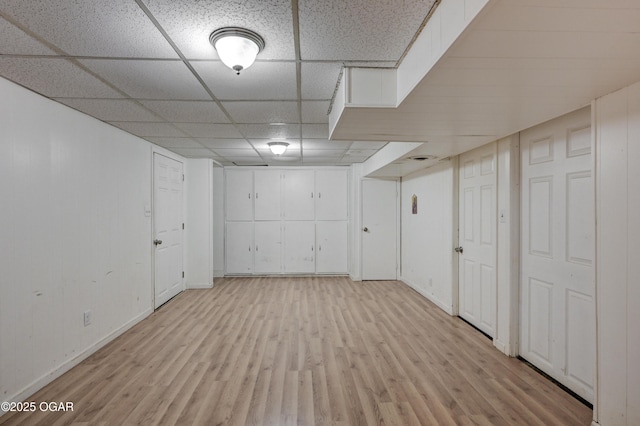 basement with a drop ceiling and light hardwood / wood-style floors