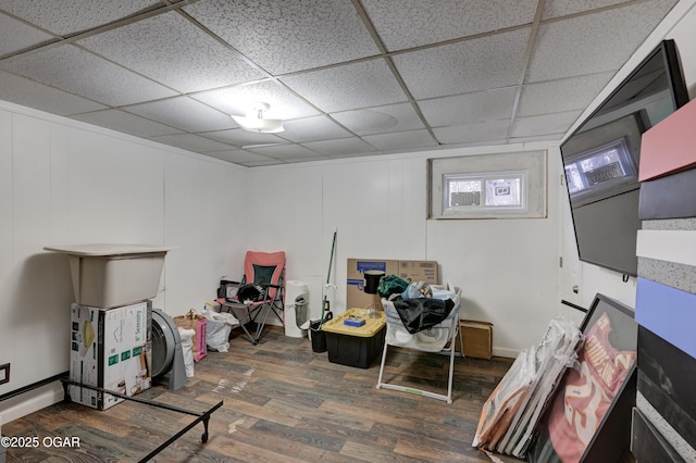 basement with a paneled ceiling and dark hardwood / wood-style flooring