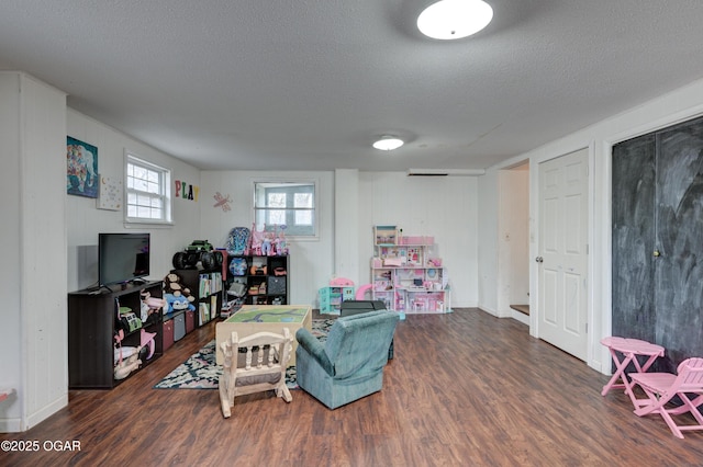 game room featuring dark hardwood / wood-style flooring and a textured ceiling