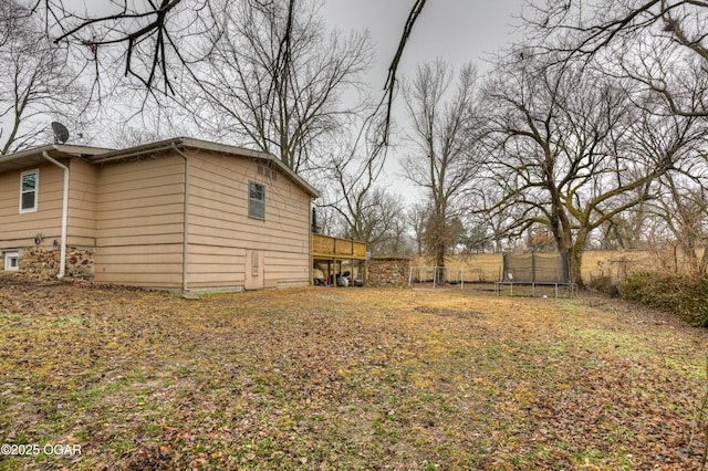 view of yard with a deck and a trampoline