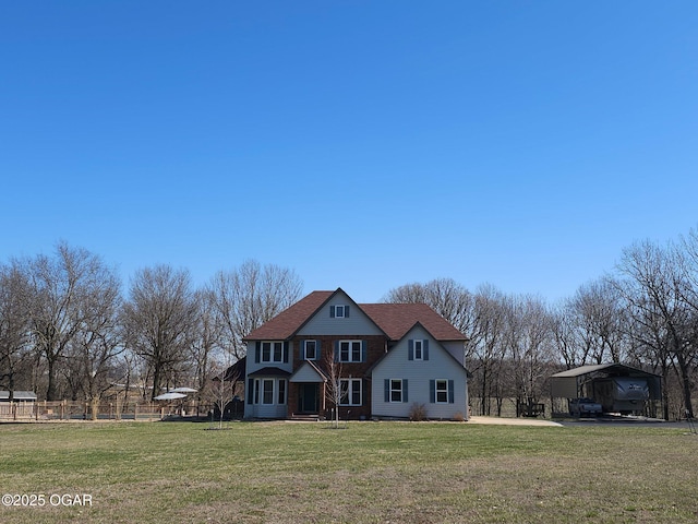 view of front of house with a front lawn, a carport, and fence