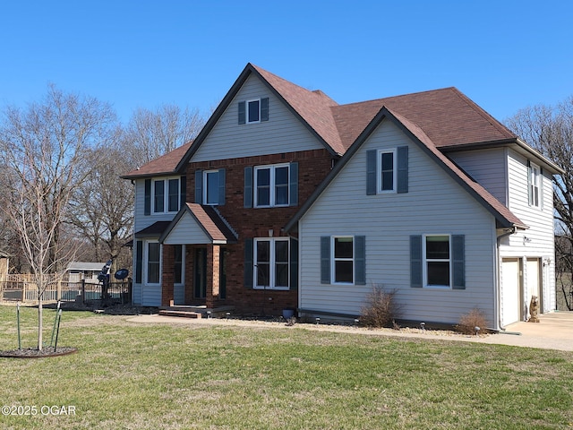 traditional-style home featuring a front yard, fence, driveway, a garage, and brick siding