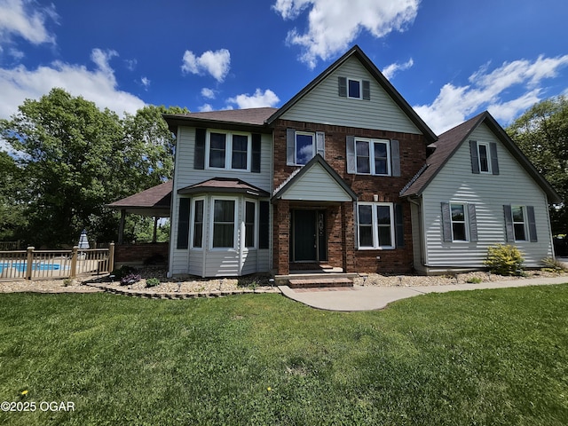 view of front of property with fence, a front yard, a fenced in pool, a shingled roof, and brick siding