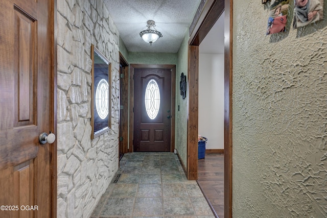 doorway to outside featuring a textured ceiling