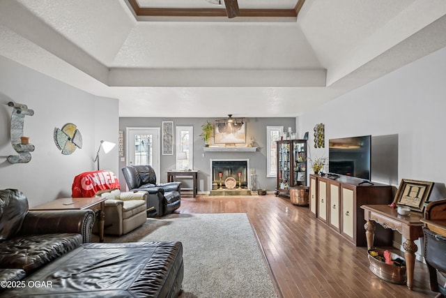 living room featuring wood-type flooring, a textured ceiling, and a tray ceiling