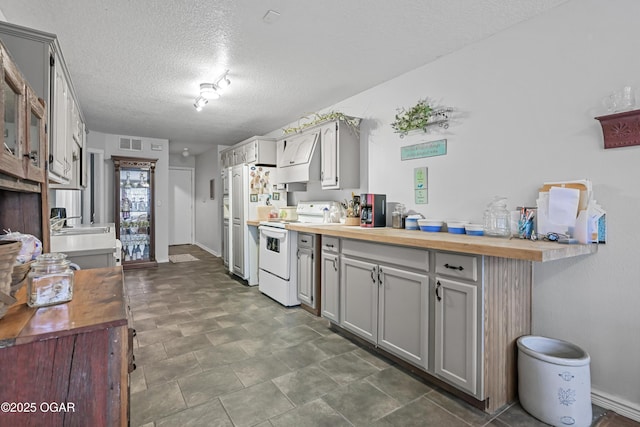 kitchen with sink, butcher block counters, gray cabinetry, white range with electric stovetop, and a textured ceiling