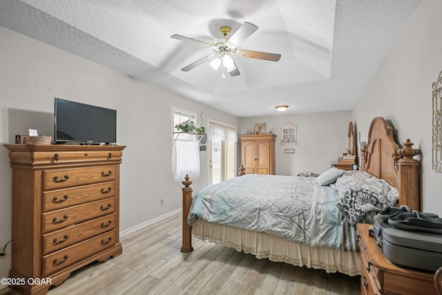 bedroom featuring ceiling fan, a textured ceiling, and light wood-type flooring