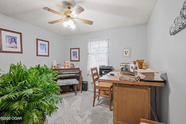 carpeted office space featuring a textured ceiling and ceiling fan