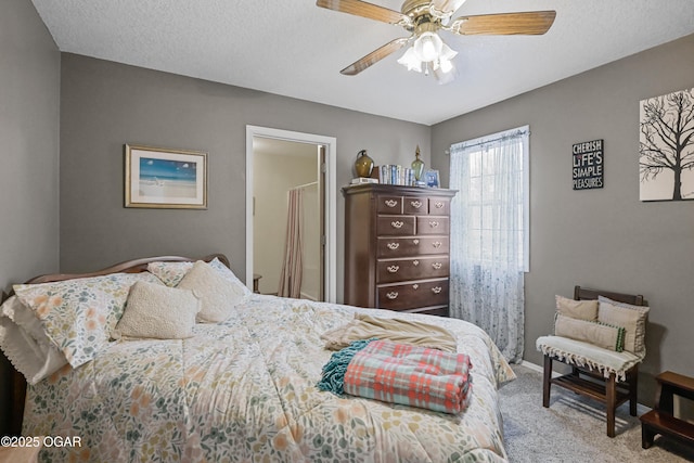 bedroom featuring ceiling fan, carpet floors, and a textured ceiling