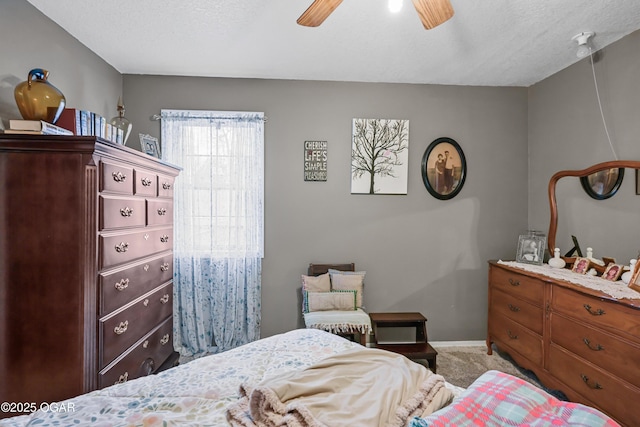 bedroom with ceiling fan, carpet flooring, and a textured ceiling