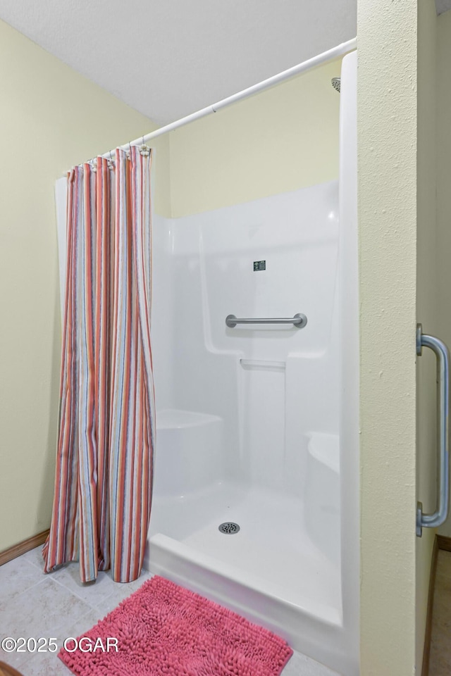 bathroom with tile patterned floors and walk in shower