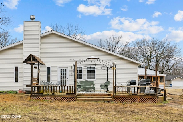 rear view of property with a gazebo, a yard, and a deck