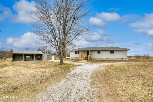 ranch-style house featuring a carport, a storage unit, and a front yard