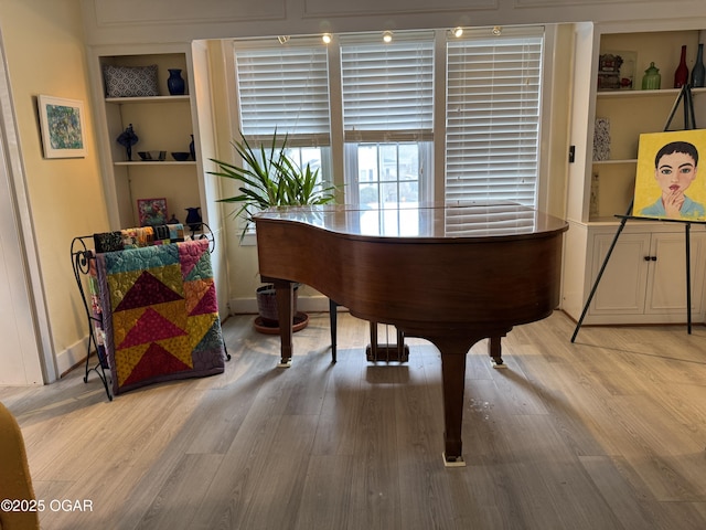 misc room featuring built in features and light wood-type flooring