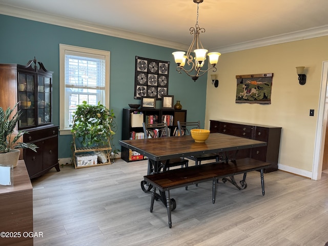 dining area featuring a notable chandelier, crown molding, and light wood-type flooring