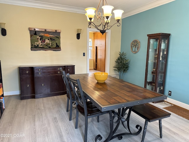 dining room with crown molding, an inviting chandelier, and light wood-type flooring