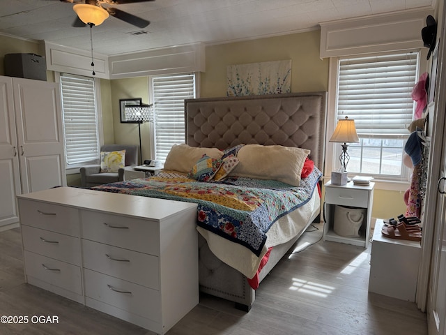 bedroom with light hardwood / wood-style flooring and ornamental molding