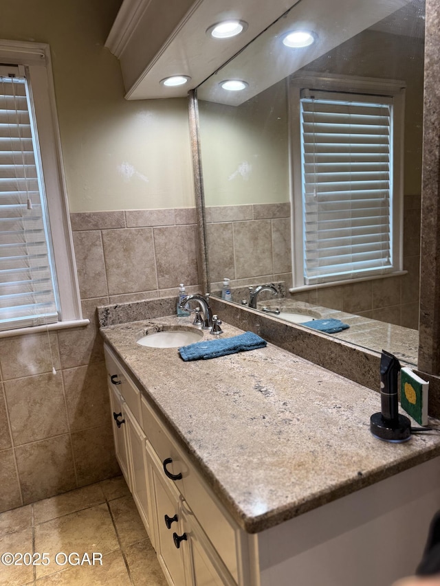 bathroom with vanity and tile walls