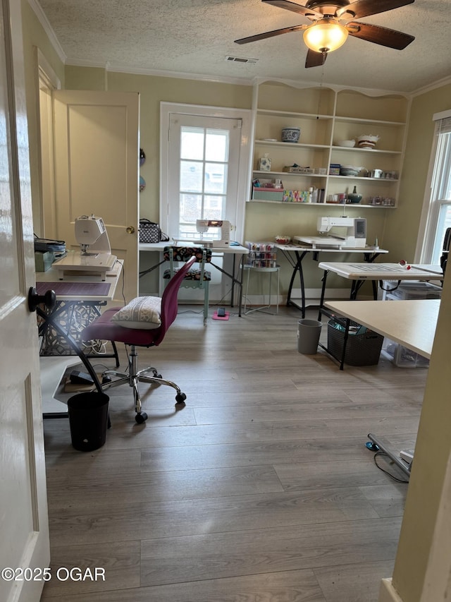 home office featuring crown molding, ceiling fan, hardwood / wood-style floors, and a textured ceiling