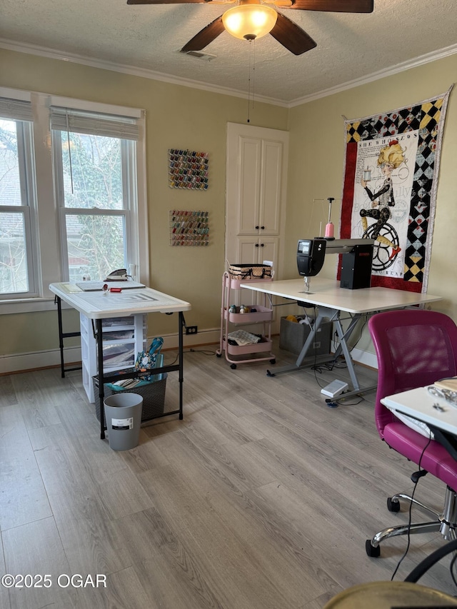 office with ceiling fan, crown molding, a textured ceiling, and light wood-type flooring