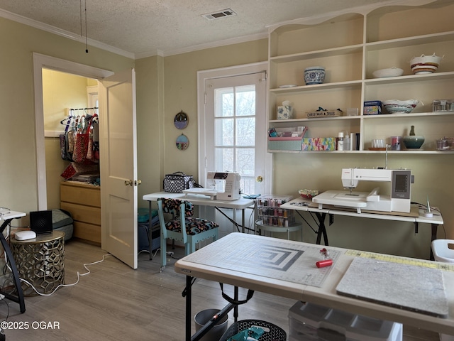 office with crown molding, a textured ceiling, and light hardwood / wood-style flooring