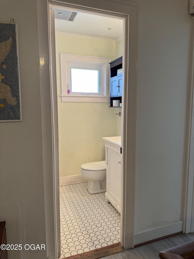 bathroom featuring vanity, crown molding, and toilet