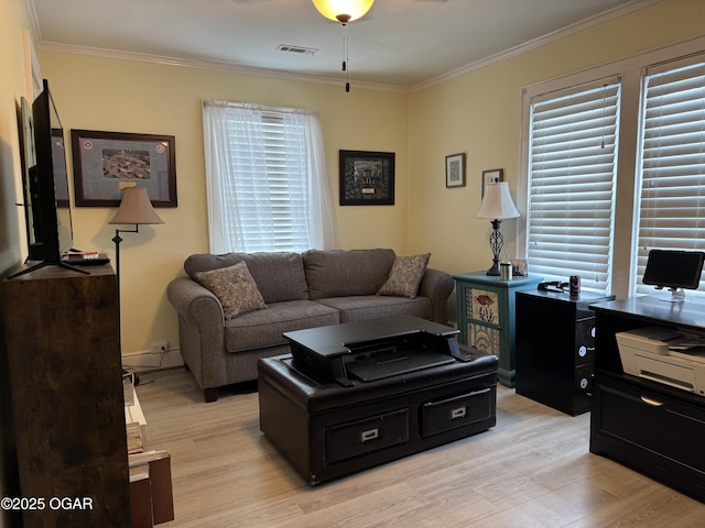 living room with light hardwood / wood-style flooring, ornamental molding, and plenty of natural light