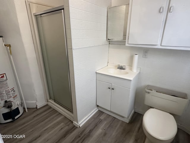 bathroom with walk in shower, vanity, hardwood / wood-style floors, and water heater