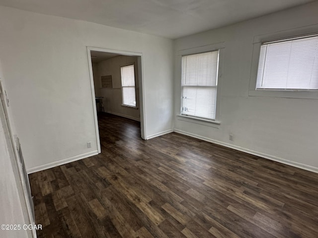 unfurnished room with a wealth of natural light and dark hardwood / wood-style floors