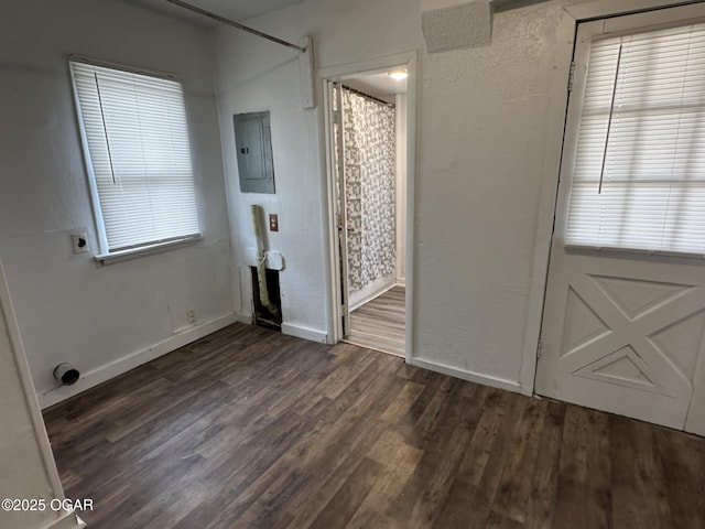 interior space featuring dark hardwood / wood-style flooring, electric panel, and multiple windows