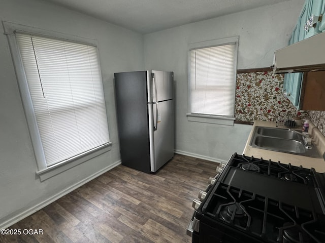 kitchen featuring sink, stainless steel refrigerator, dark hardwood / wood-style floors, ventilation hood, and gas stove