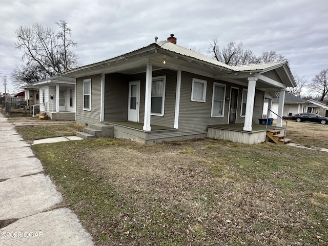 view of side of home with a yard and a porch