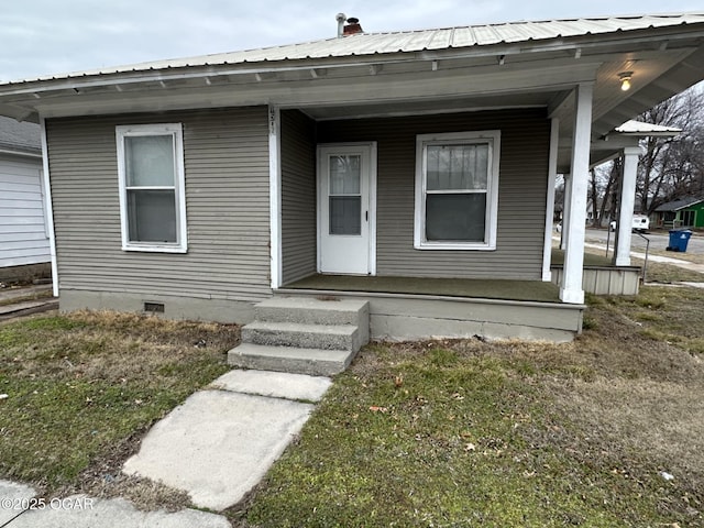 property entrance featuring a porch and a yard