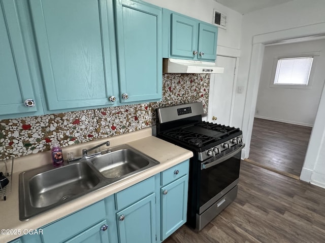 kitchen with sink, gas range, dark wood-type flooring, and blue cabinets