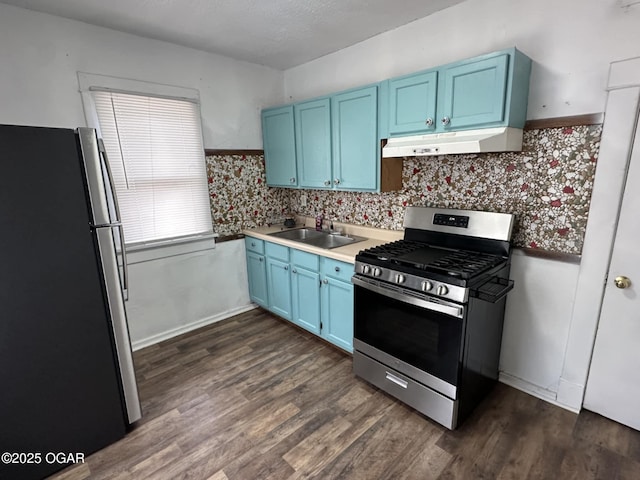 kitchen with sink, dark wood-type flooring, stainless steel appliances, and blue cabinets