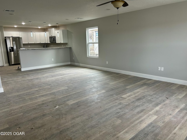 unfurnished living room featuring ceiling fan and light wood-type flooring