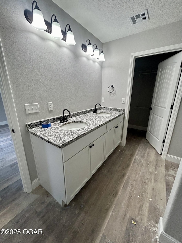 bathroom featuring vanity, hardwood / wood-style floors, and a textured ceiling