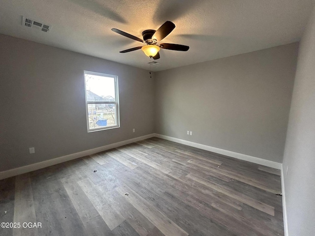 spare room with ceiling fan, wood-type flooring, and a textured ceiling