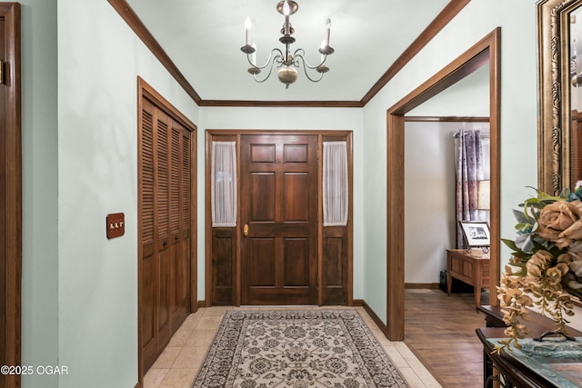 entrance foyer with crown molding, light wood-type flooring, and an inviting chandelier