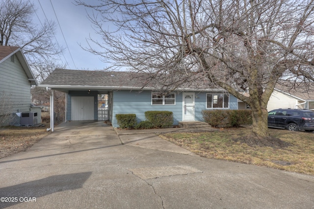 view of front of home with a carport and central AC unit